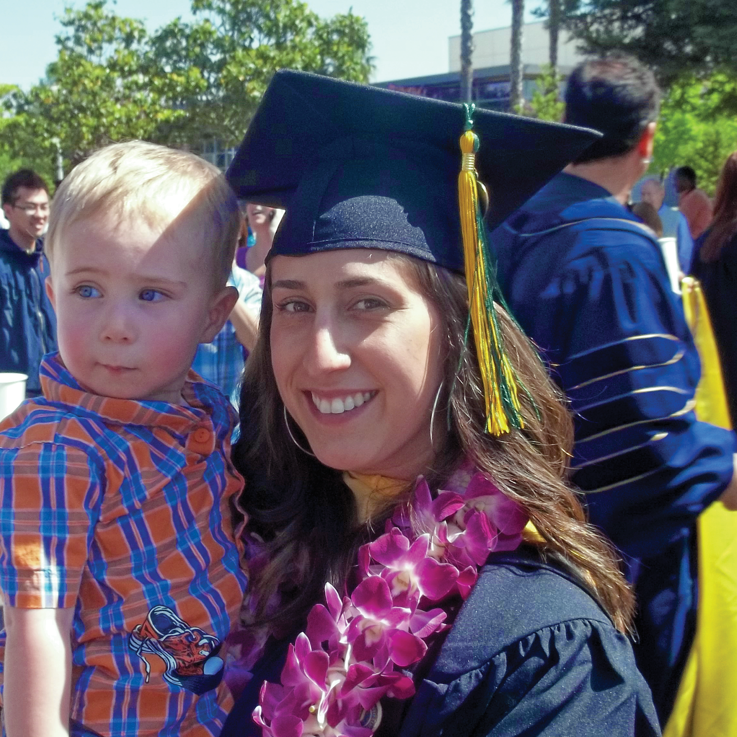 woman graduating holding child