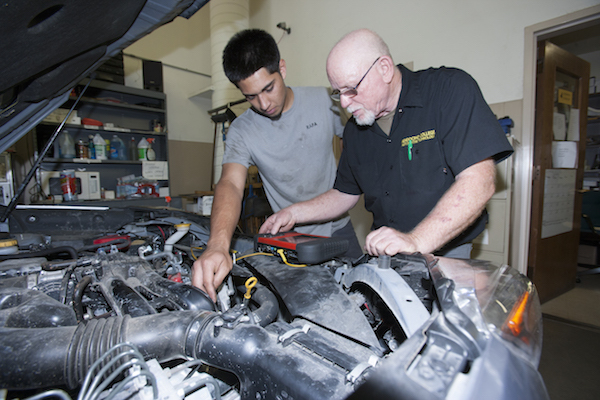 student and instructor work on car engine