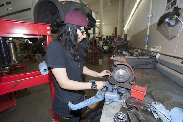 auto student girl preparing a metal piece