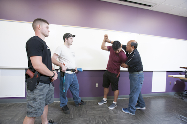 instructor demonstrating handcuffing technique