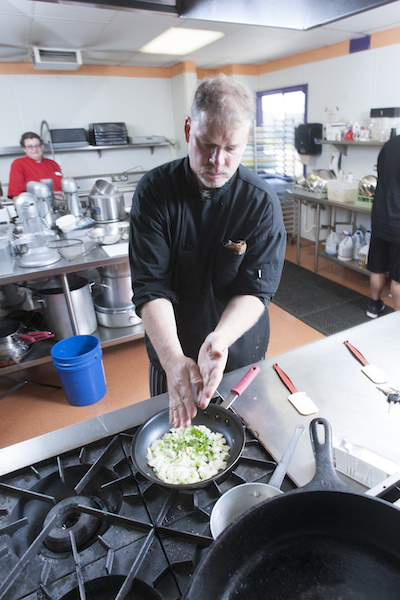 culinary student sautéing onions