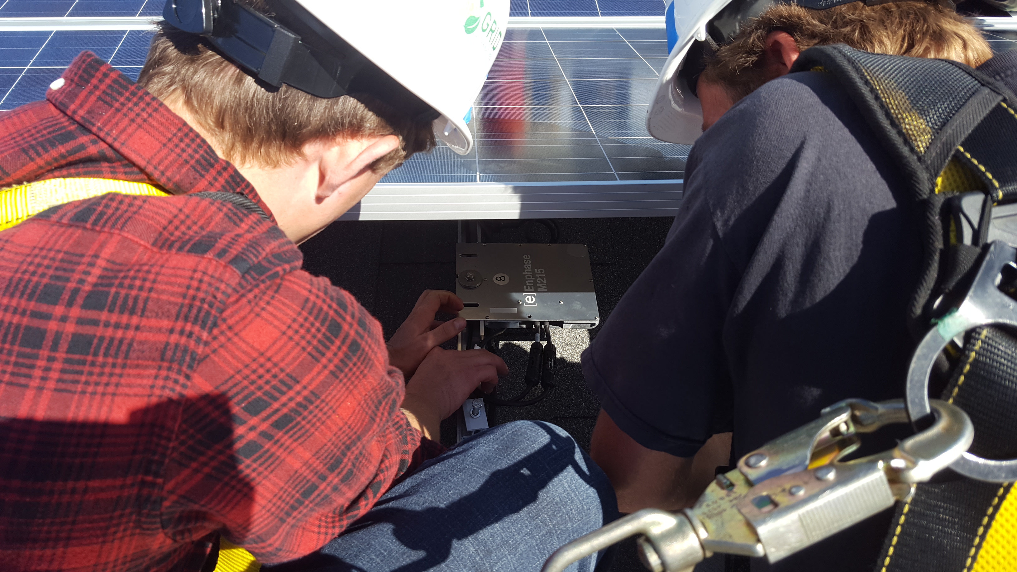 two students bolt solar panels down