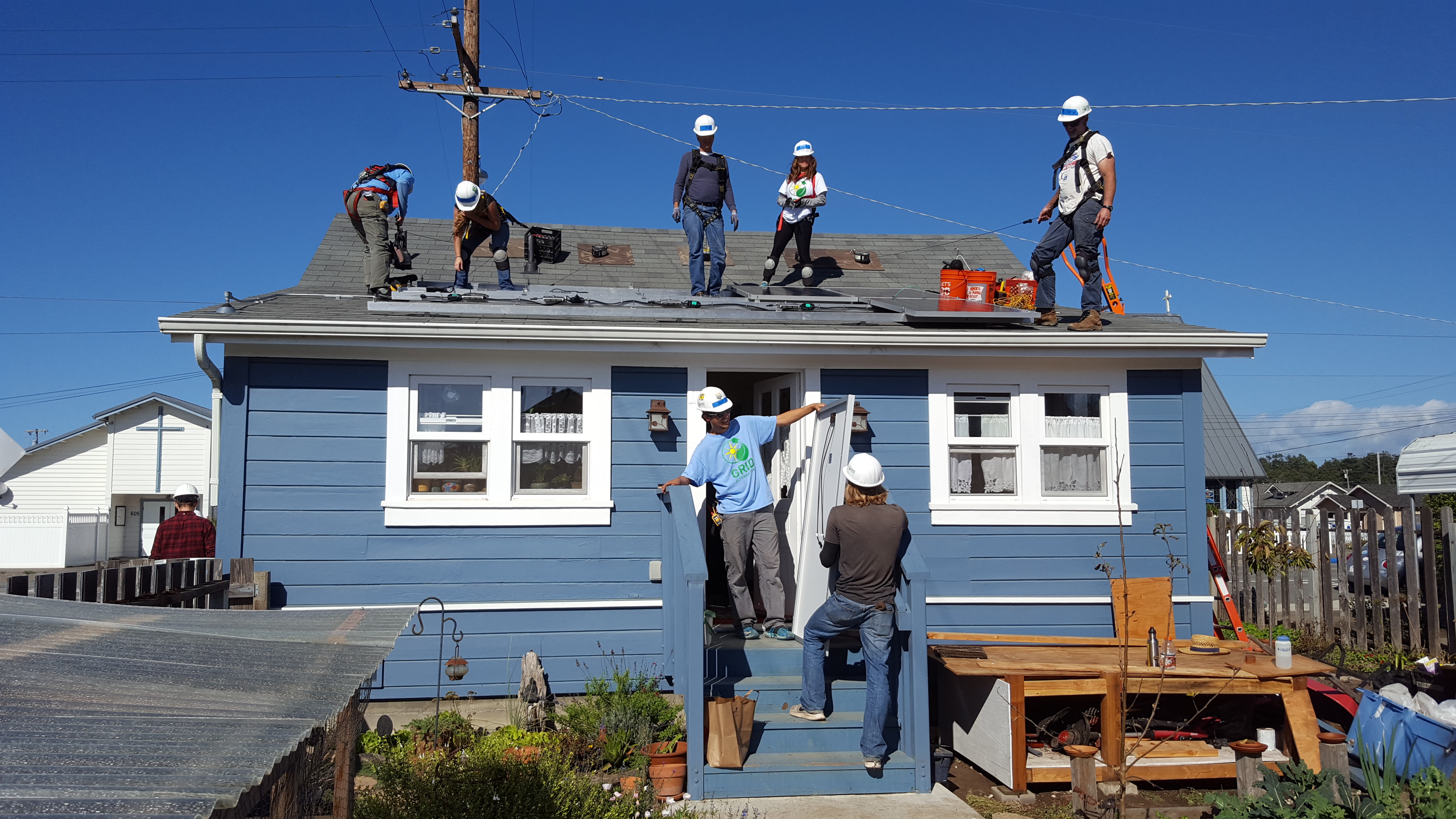 students install solar panels on the roof of a house