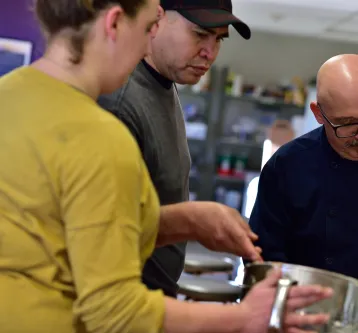 Chef instructor teaching students with bowls