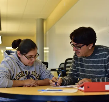 Student and teacher reading document together