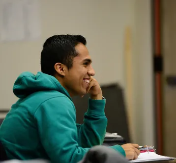 Young man student in class smiling