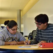 Student and teacher reading document together