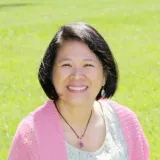 woman with black hair and pink sweater